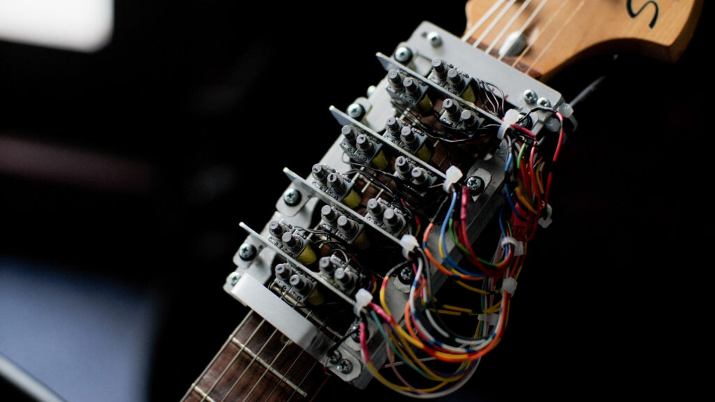 Craig's guitar fretboard with additional component. The robotic component allows for a machine learning programme to fret notes whilst Craig plays